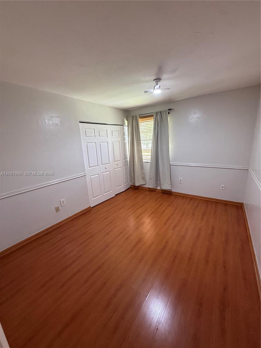 10661 Southwest 113th Place, Unit 94B Miami, FL 33176 - Photo 35 of 54 an empty room with wooden floor and windows