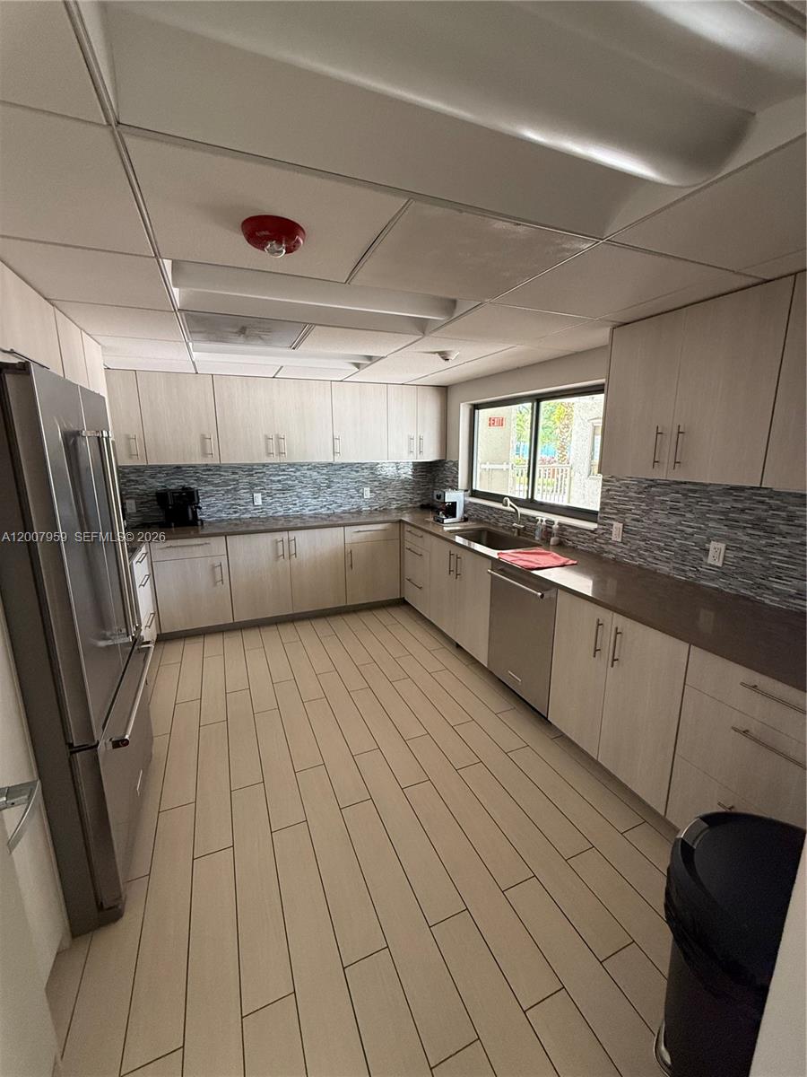 10661 Southwest 113th Place, Unit 94B Miami, FL 33176 - Photo 42 of 54 a kitchen with stainless steel appliances granite countertop a sink and white cabinets