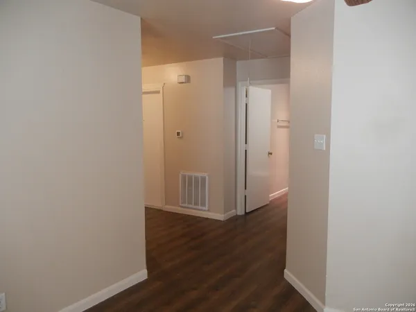 a view of a hallway with wooden floor