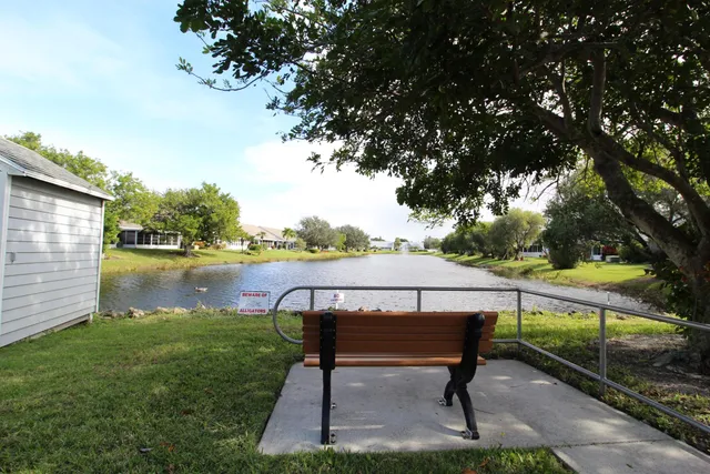 a view of a lake with table and chairs under an umbrella