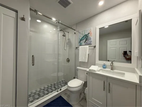 a bathroom with a toilet sink shower and a mirror