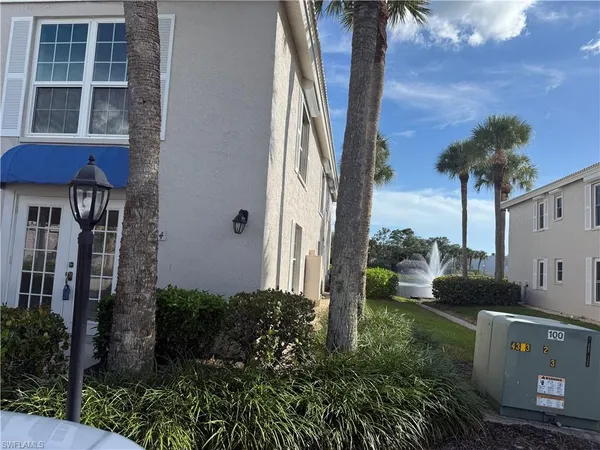 a view of a house with a yard and potted plants