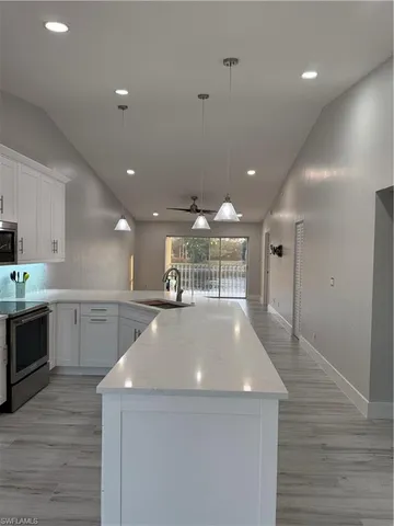 a view of a kitchen with a sink and dishwasher a refrigerator with wooden floor