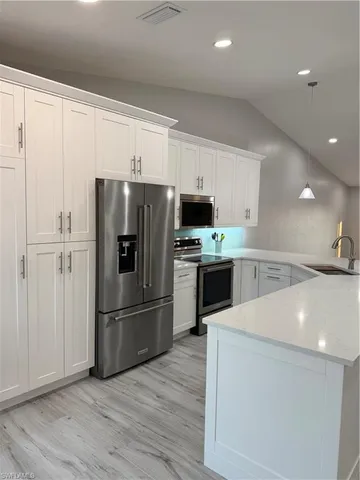 a kitchen with stainless steel appliances a refrigerator sink and microwave