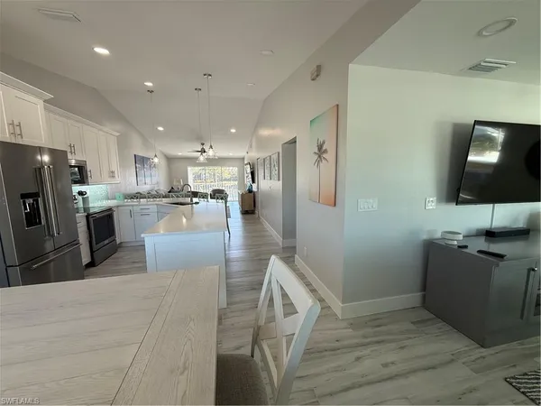 a kitchen with stainless steel appliances kitchen island granite countertop a refrigerator and a stove top oven