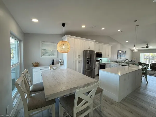 a view of kitchen with refrigerator dining table and chairs