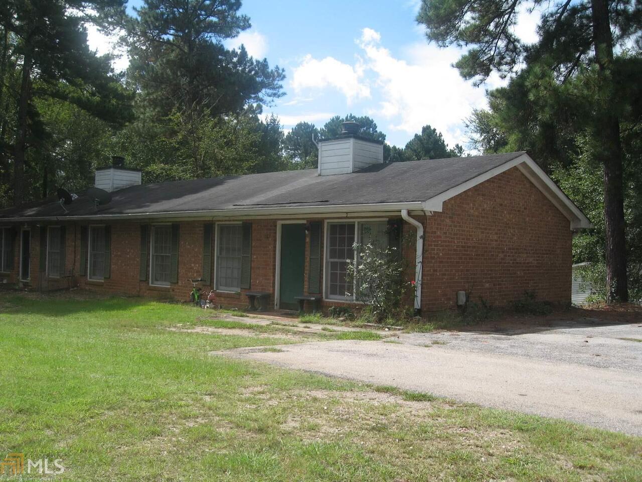 a front view of a house with a garden and yard