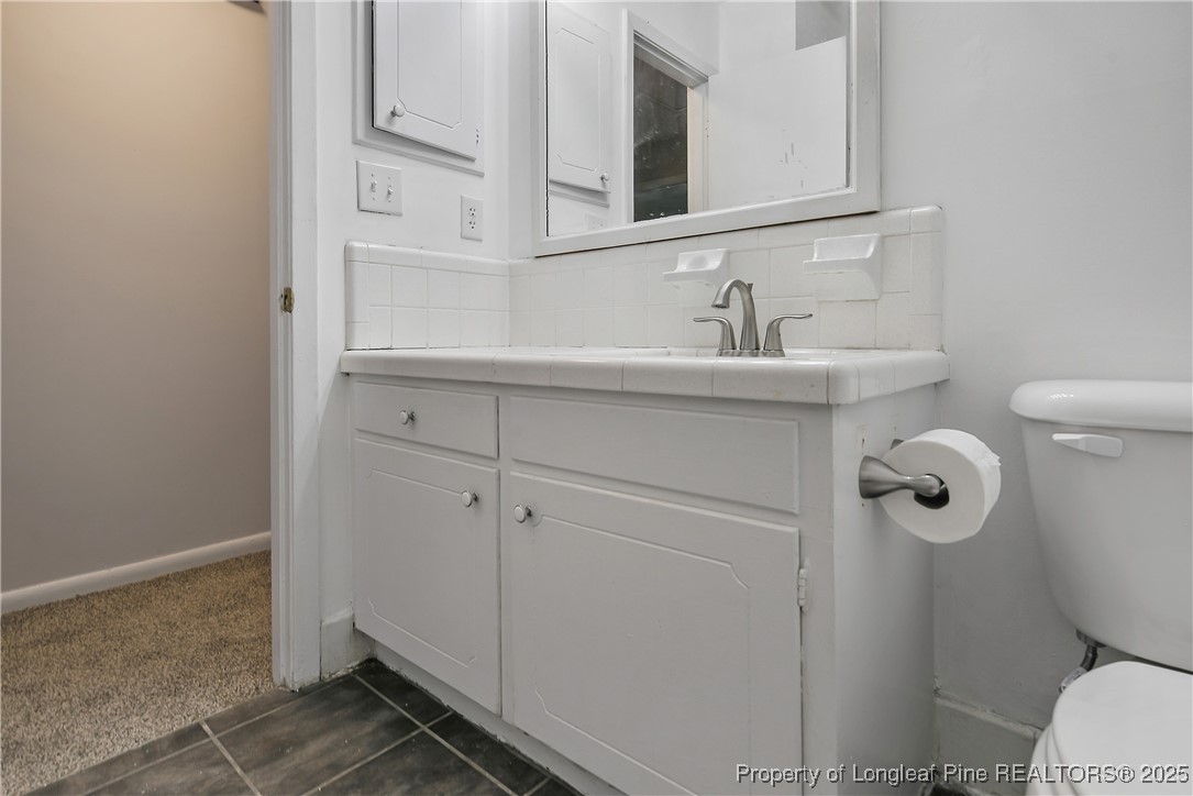 7118 Fillyaw Road Fayetteville, NC 28303 - Photo 34 of 45 a bathroom with a sink toilet and mirror