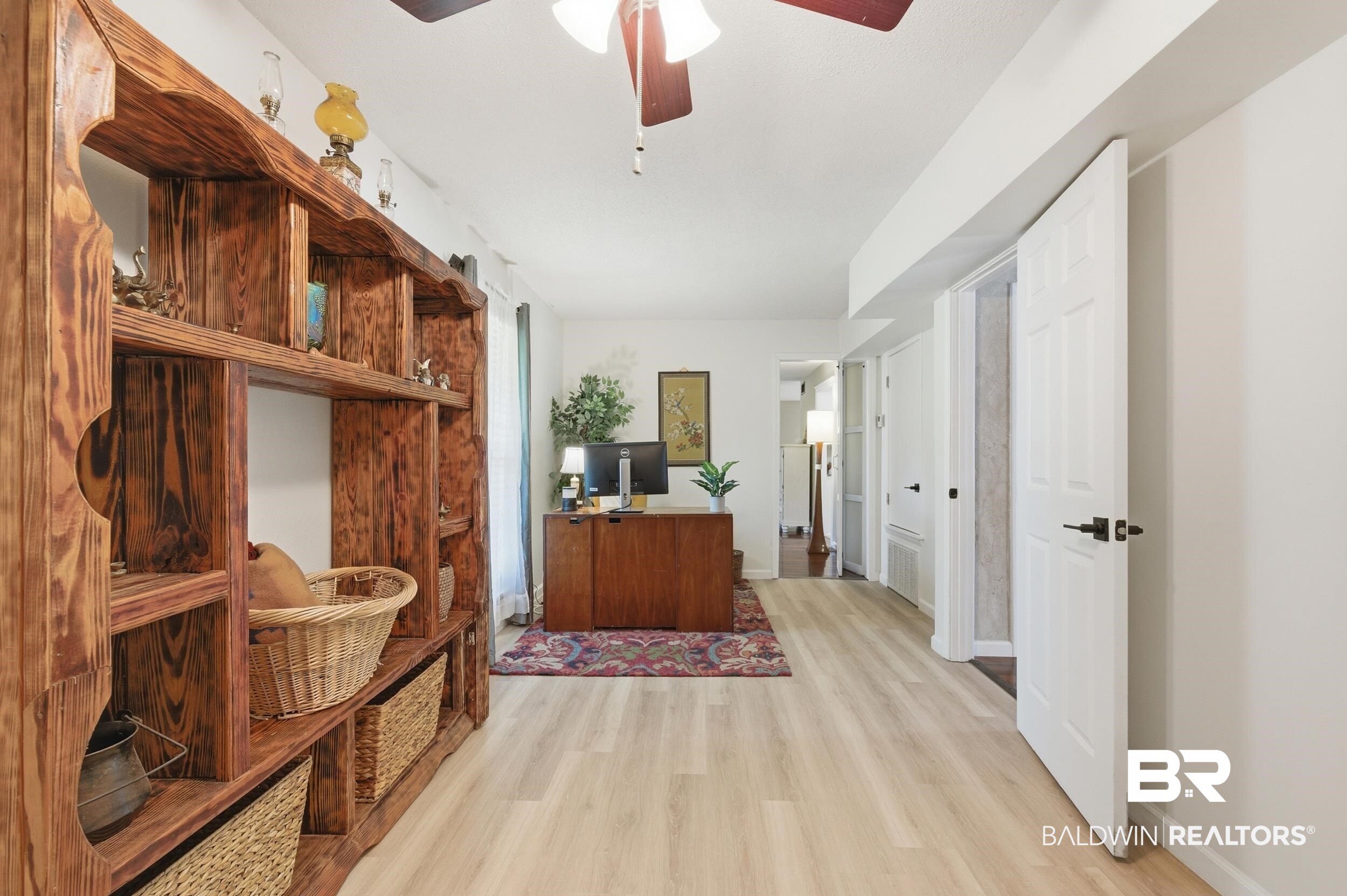 51620 Robert White Road Bay Minette, AL 36507 - Photo 16 of 81 Built-in wood shelving unit, light wood-finish flooring, white paneled doors, and a ceiling fan with integrated lighting
