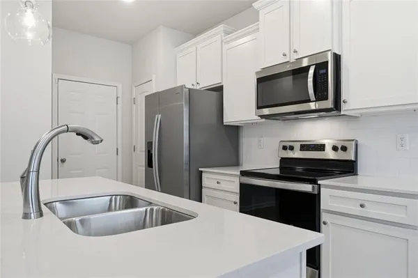 a kitchen with stainless steel appliances granite countertop a sink and a microwave