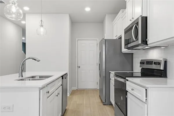 a kitchen with stainless steel appliances granite countertop a sink a stove a refrigerator and a microwave