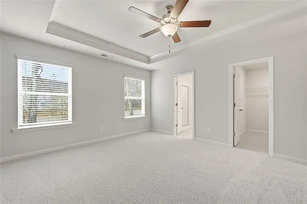 an empty room with closet and fan