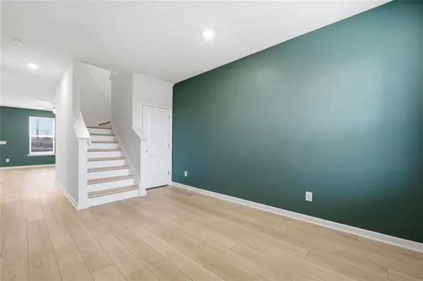 an empty room with wooden floor and stairs