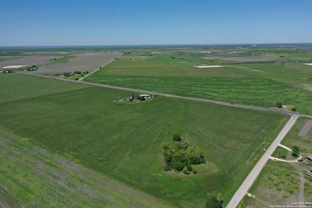 a view of a green field with lots of bushes