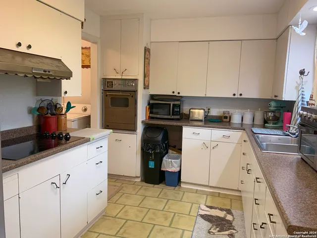 a kitchen with a sink and white cabinets
