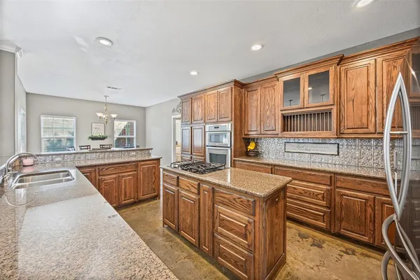 a kitchen with stainless steel appliances granite countertop a sink stove and cabinets
