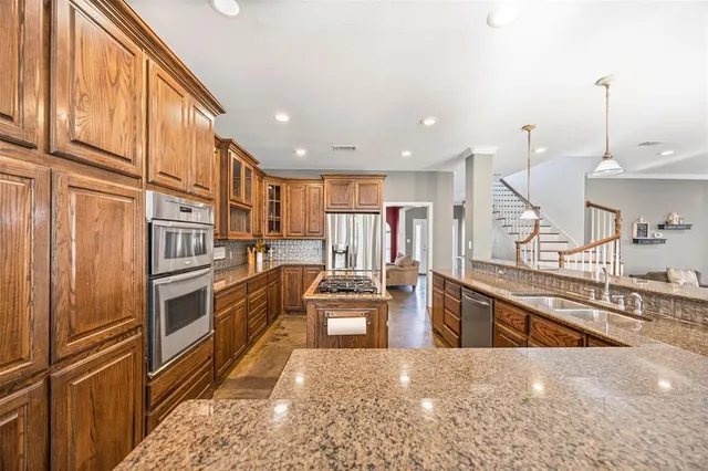 a kitchen with stainless steel appliances granite countertop a refrigerator and a stove