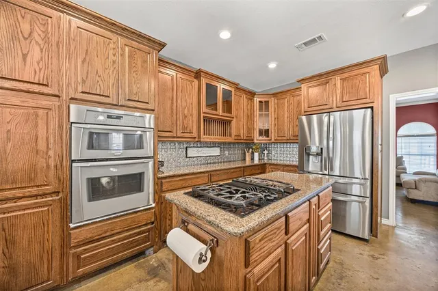 a kitchen with stainless steel appliances granite countertop a stove microwave and refrigerator