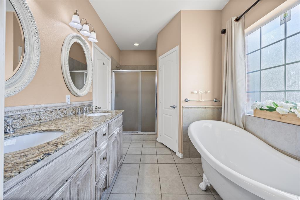 905 Royse Ridge Road Ennis, TX 75119 - Photo 23 of 38 a spacious bathroom with a granite countertop sink and a mirror