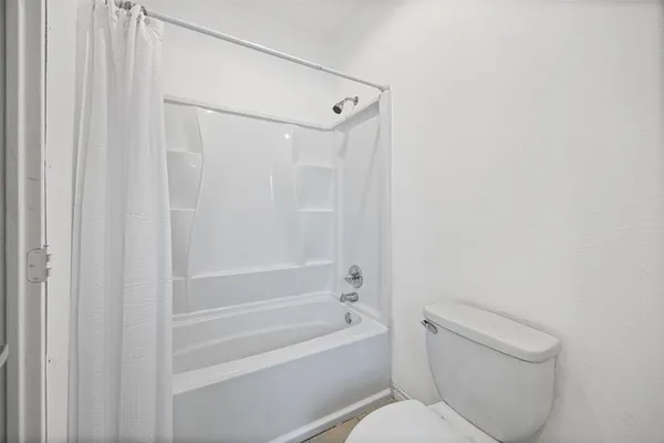 a bathroom with a toilet and a bathtub