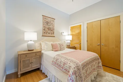 a bedroom with a bed and a lamp on dresser