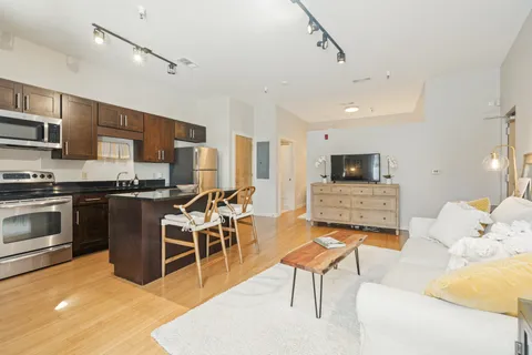 a living room with stainless steel appliances kitchen island granite countertop furniture and a kitchen view