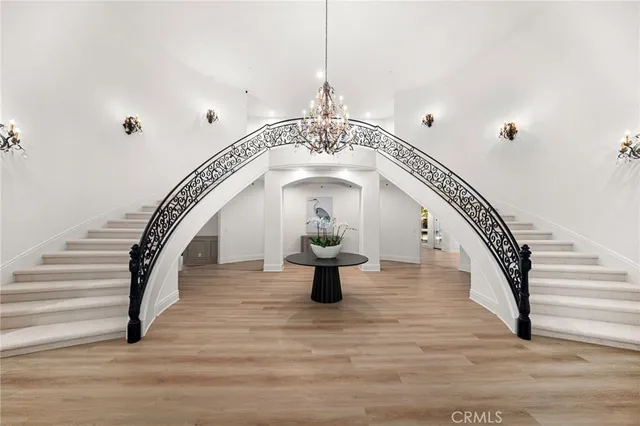 a large kitchen with stainless steel appliances a large counter top a sink a oven and wooden floors