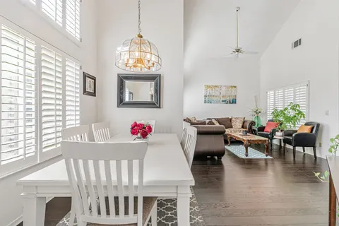 a living room with furniture two window and wooden floor