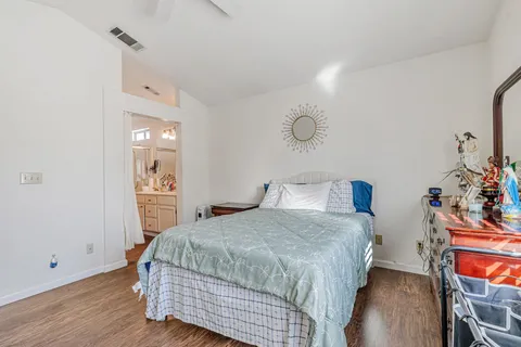 a bedroom with a bed and wooden floor