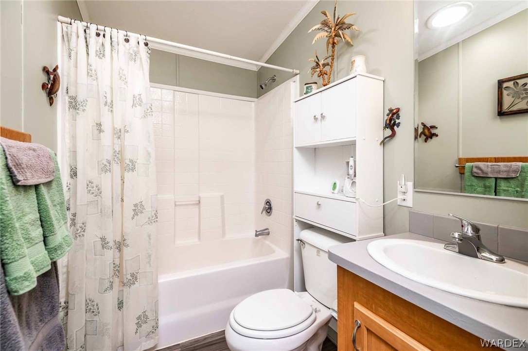 3285 Kelvin Road Golden Valley, AZ 86413 - Photo 16 of 43 a bathroom with a granite countertop sink toilet a mirror a vanity and shower