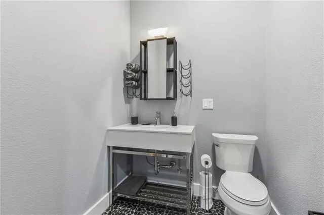 a bathroom with a toilet a sink and mirror