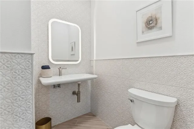 a bathroom with a toilet a sink and mirror