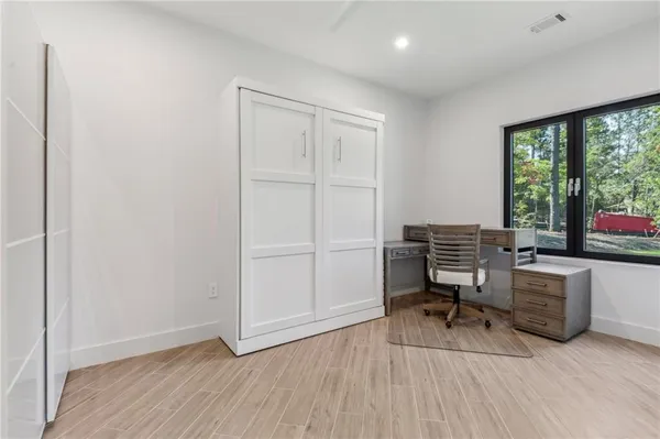 a view of a workspace with furniture and a window