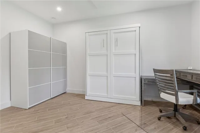 a view of an empty room with wooden floor and closet