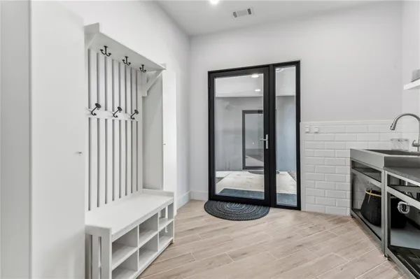a view of a hallway with entryway and wooden floor