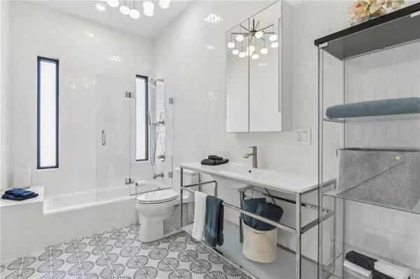 a bathroom with a double vanity sink a toilet a shower and a bathtub
