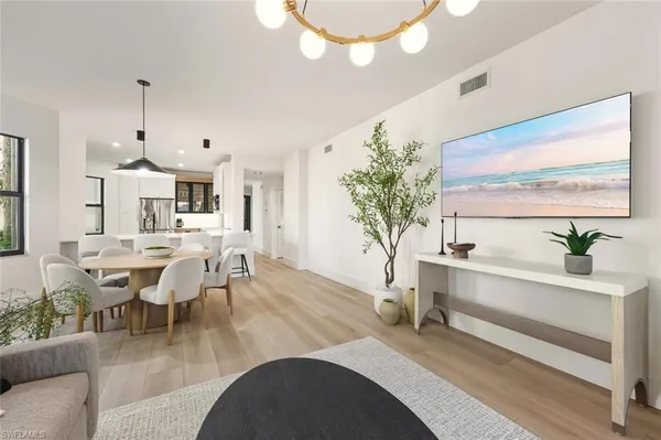 a living room with furniture a chandelier and a dining table