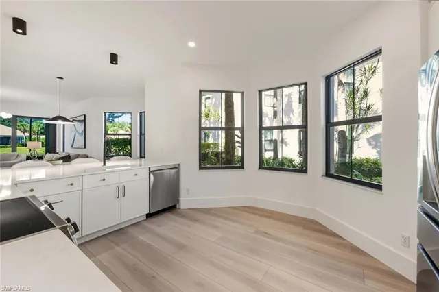 a large white tub sitting in a room next to a large window