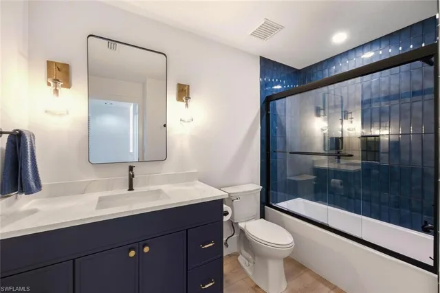 a bathroom with a double vanity sink toilet and shower