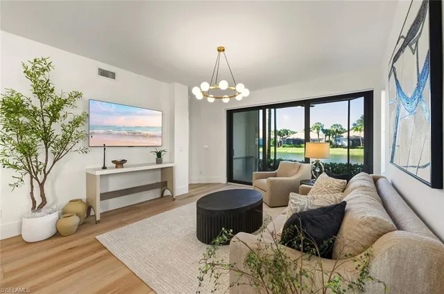 a living room with furniture potted plant and a large window