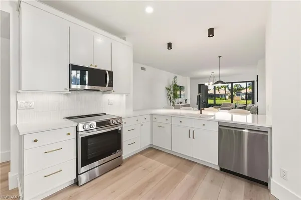 a kitchen with granite countertop appliances cabinets and a sink