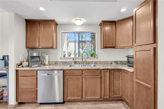 a kitchen with granite countertop stainless steel appliances a sink and cabinets