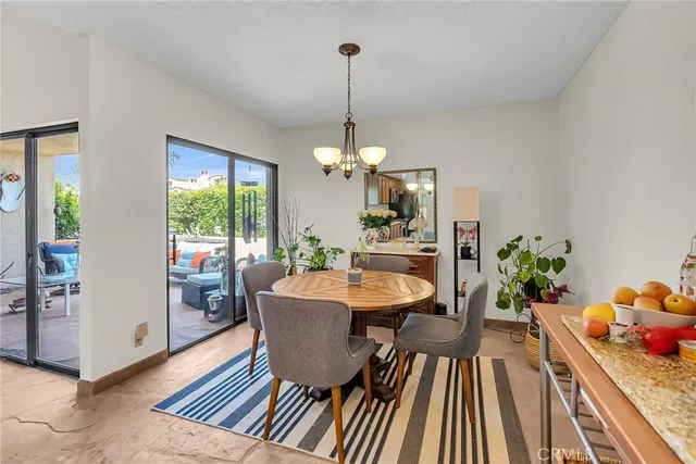 a dining room with furniture a chandelier and wooden floor