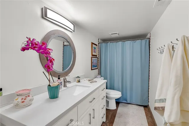 a bathroom with a sink mirror and toilet