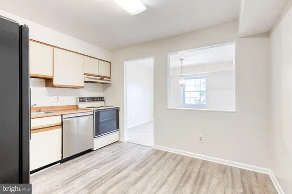 a kitchen with a white cabinets and window