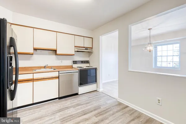 a kitchen with kitchen island granite countertop white cabinets and white appliances