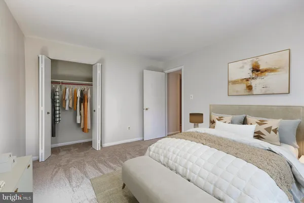 a bedroom with a bed and a painting on the wall