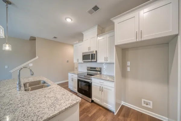 a bathroom with a granite countertop sink a bathtub a mirror and vanity