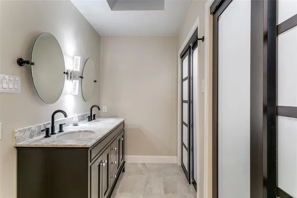 a bathroom with a double vanity sink and a mirror