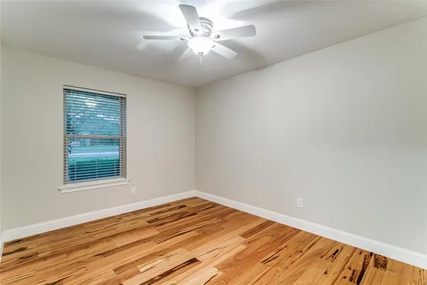 a view of a room with wooden floor and a ceiling fan